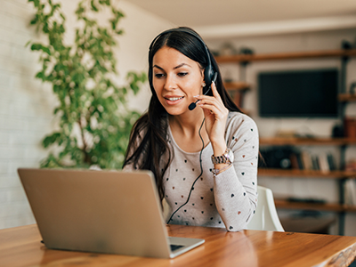 woman with headset on laptop